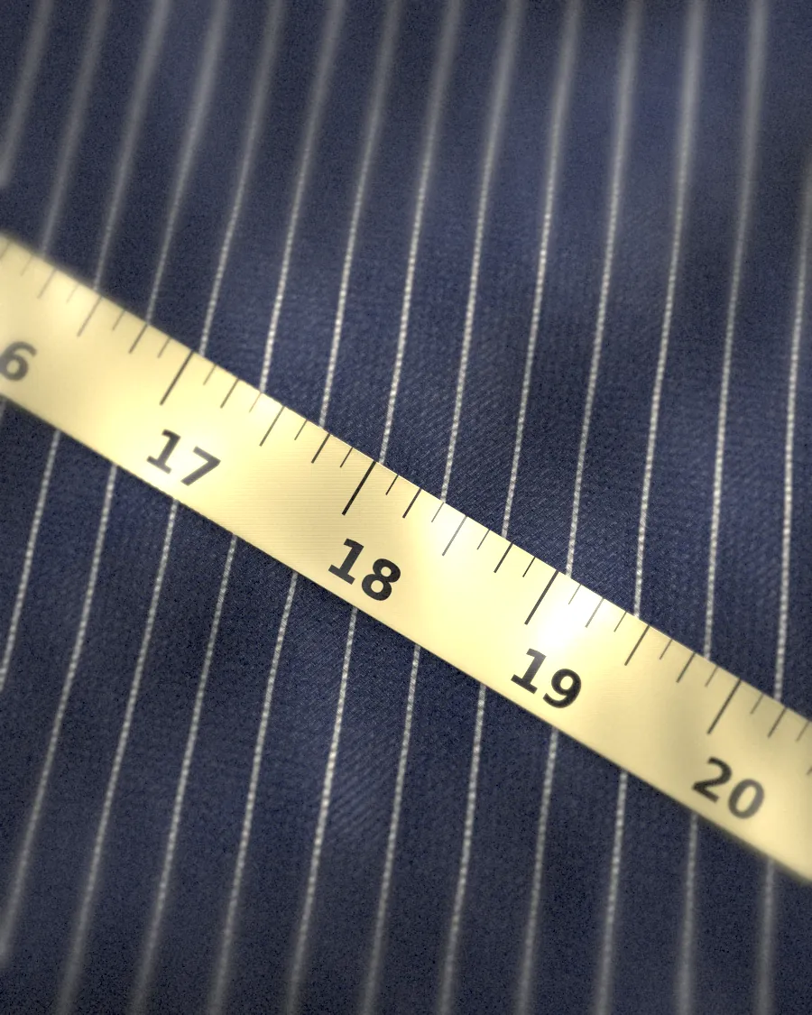 A measuring tape across pinstripe cloth
